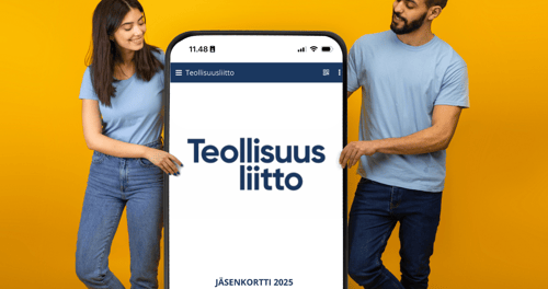 Kaksi ihmistä pitelee yhdessä suurta älypuhelinta keltaisella taustalla, ja puhelimen näytöllä näkyy Teollisuusliiton digitaalinen jäsenkortti vuodelle 2025.